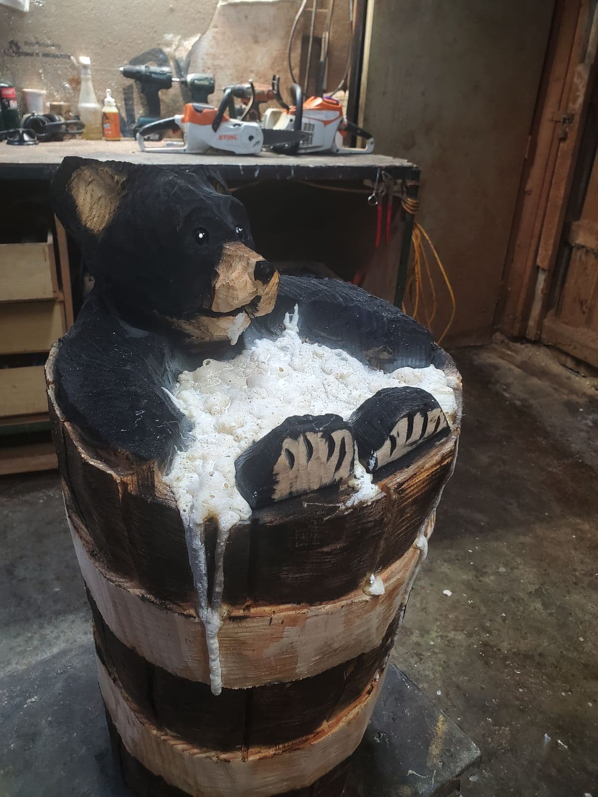Black bear carving soaking in a wooden tub full of suds