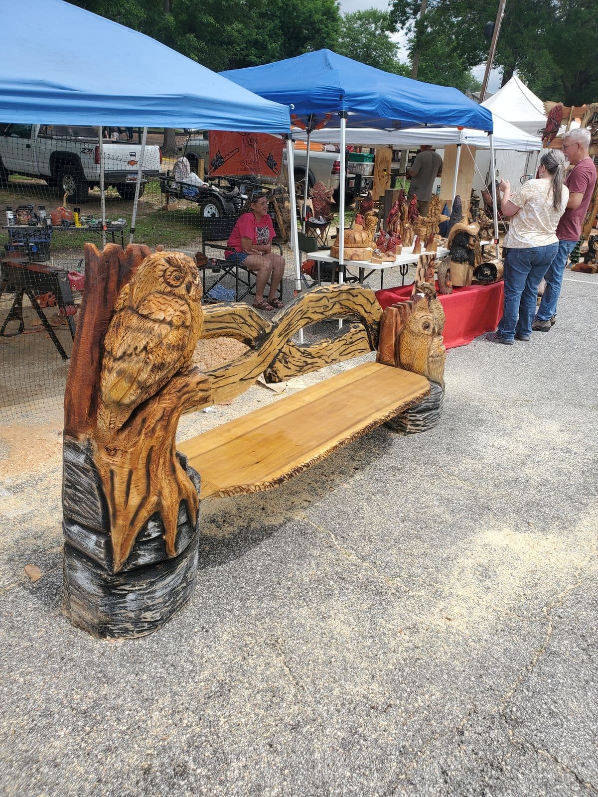 Live-edge bench with an owl carved on a branch at one end