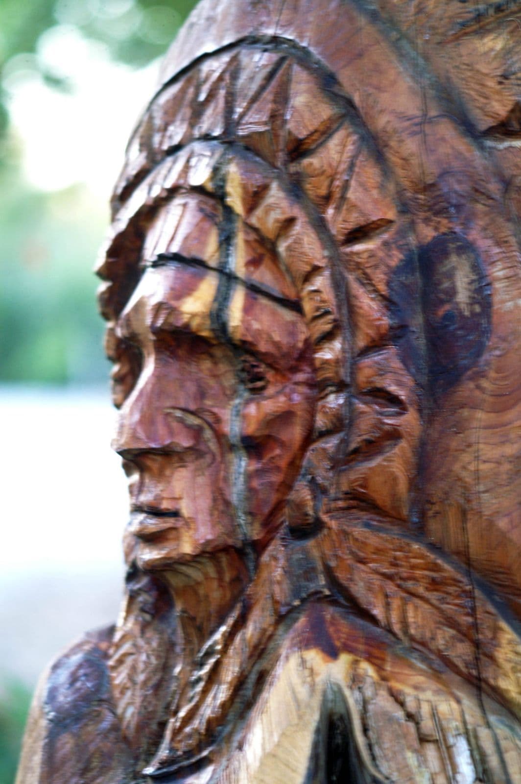Close-up of a carved face in a feathered headdress