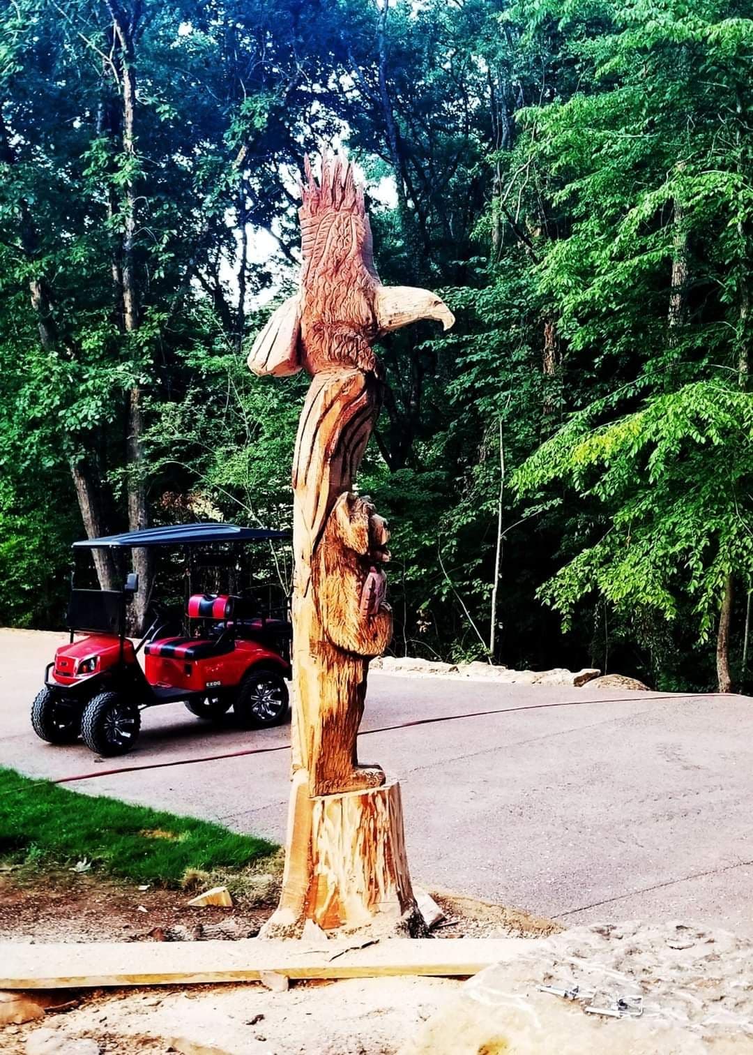 Standing tree trunk carved into an eagle perched above a leaping fish